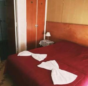 马德普拉塔Nuevo Hotel Tivoli的一张红色的床,上面有两条白色的毛巾