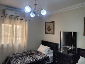 开罗Logistic Apartment的一间卧室配有一张床、梳妆台和吊灯。