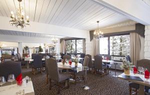 谷雪维尔Odalys Hotel New Solarium的用餐室设有桌椅和窗户。