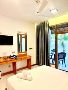 马米基里Vilu Residence的酒店客房,配有床和电视