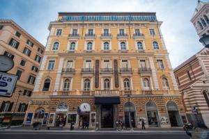 罗马La Griffe Hotel Roma的一条城市街道上的黄色大建筑
