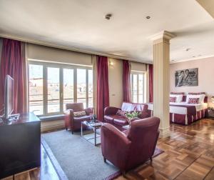 罗马La Griffe Hotel Roma的客厅配有沙发和桌子