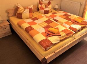 施莱茨Pension 'Am Vogelherd'的一张带 ⁇ 子毯子和枕头的床