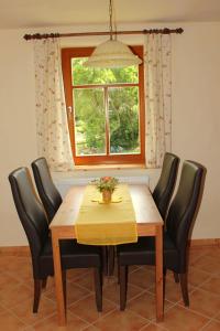 施莱茨Pension 'Am Vogelherd'的一张带黑色椅子的餐桌和窗户