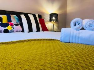 利明顿温泉Lux Home Stays - Regents Place的一间卧室配有一张带黄色毯子的大床