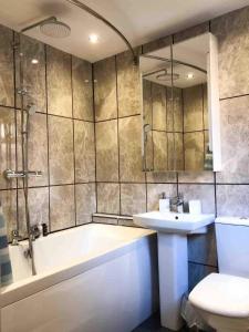 利明顿温泉Lux Home Stays - Regents Place的带浴缸、盥洗盆和卫生间的浴室