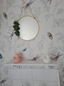 斯托诺韦Cosy home的浴室设有镜子和带蝴蝶的架子