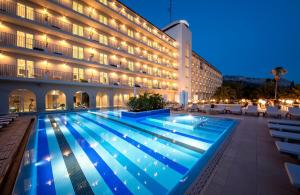图彻皮Bluesun Hotel Jadran的晚上在酒店前面的一个游泳池