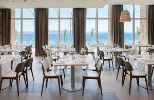 图彻皮Bluesun Hotel Jadran的餐厅设有桌椅和窗户。