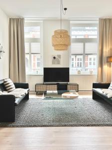 代特莫尔德MAKERS + ROOMS APARTMENTS的客厅配有2张沙发和1台平面电视