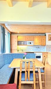 KaunerbergApartments Amelie Kaunerberg -1-的厨房配有木桌和蓝色沙发。