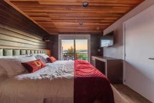 圣弗朗西斯科-迪保拉Bourbon Serra Gaúcha Divisa Resort的一间卧室设有一张带木制天花板的大床