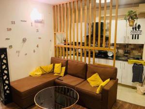 伊斯兰堡Entire One Bedroom Furnished Apartment的客厅配有带黄色枕头的棕色沙发