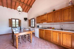 甘巴西泰尔梅Podere Boscone的厨房配有木制橱柜和木桌。