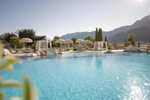 阿皮亚诺苏拉斯特拉达Weinegg Wellviva Resort的一个带椅子和遮阳伞的大型游泳池