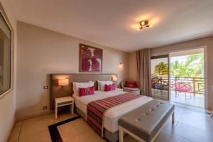 Ambondrona棕榈滩度假村及Spa的一间带大床的卧室和一个阳台