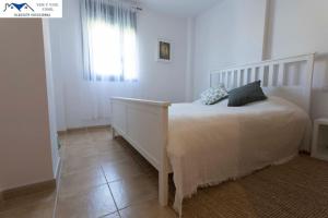 科尼尔-德拉弗龙特拉APARTAMENTO TREBUJENA的卧室配有白色的床和窗户。