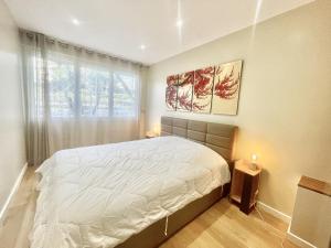 戛纳Rosalia Luxury 3 bedrooms near beaches by Welcome to Cannes的一间卧室设有一张大床和一个窗户。