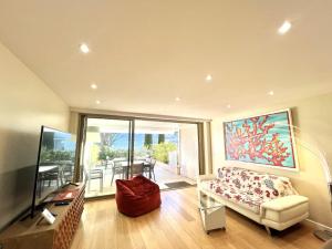 戛纳Rosalia Luxury 3 bedrooms near beaches by Welcome to Cannes的带沙发和玻璃桌的客厅