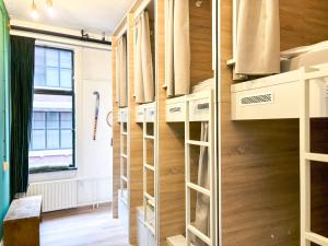 鹿特丹鹿特丹旅舍的一间设有木制架子和窗户的房间