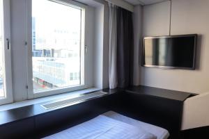 斯德哥尔摩舒适快捷酒店斯德哥尔摩中心酒店的配有电视和窗户的酒店客房