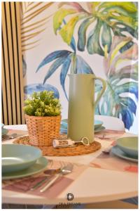 米兰DEA DREAMS Amendola Fiera Apartment Free Wi-Fi的一张桌子,上面有绿色投手和植物