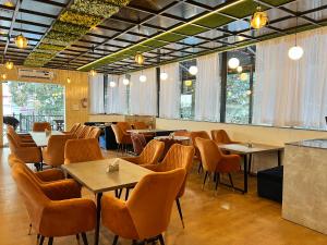 穆索里Wabi Sabi Stays - Pride Inn的用餐室设有桌椅和窗户。