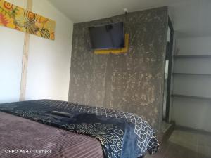 蒙圭CASA BAHAREQUE HOSPEDAJE的一间卧室配有一张床,墙上配有电视