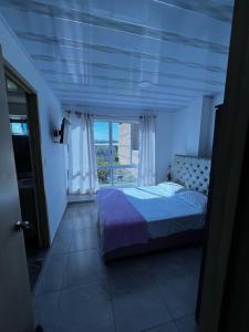 皮塔利托Apto Escalini Mansión Pitalito的一间卧室设有一张床和一个大窗户
