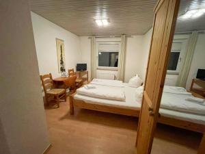 Groß Sarau诺比斯克鲁格酒店的一间卧室配有两张床和一张桌子及椅子