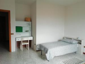TrataliasSu domus de Corinne的一间卧室配有一张床和一张带一张小床的桌子。