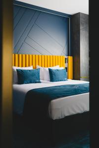 华沙Stay inn Hotel Warszawa的一间卧室配有一张带橙色床头板的大床