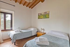 圣吉米纳诺Fattoria La Torre的一间卧室设有两张床和窗户。