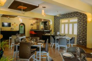 比纳里姆Carina Beach Resort - 10mins walk to Benaulim Beach的一间带桌椅的餐厅和一间酒吧