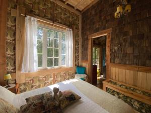 卡斯特鲁La Casita del Bosque的一间卧室设有一张大床和一个窗户。