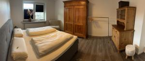 锡默拉特Kragemann Hotel & Vinothek的一间卧室配有一张床和一个木制橱柜