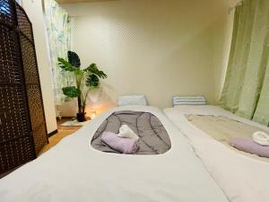大阪難波心斎橋10 minutes民宿3号室的一间卧室配有两张床和一张猫床