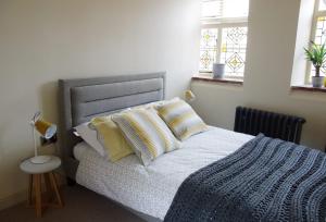 诺里奇Studio 4- 6 Norwich City Centre Apartment的一间卧室配有一张带蓝色毯子的床和两个窗户。