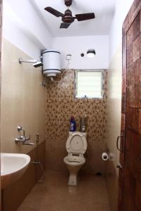 kolkataLOTUS APARTMENTS HOTEL的一间带卫生间和水槽的浴室以及吊扇。