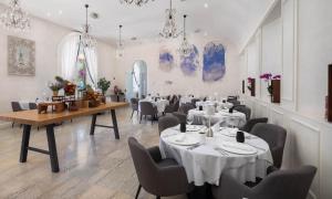 科尔丘拉Aminess Korcula Heritage Hotel的用餐室配有桌椅和吊灯。