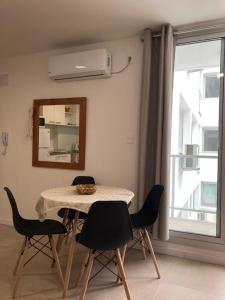 梅塞德斯Apartamento céntrico en Mercedes Uruguay的一间带桌椅和镜子的用餐室
