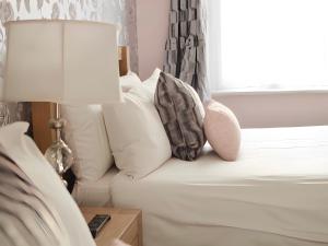 南安普敦明星酒店的一间卧室配有带枕头和台灯的床
