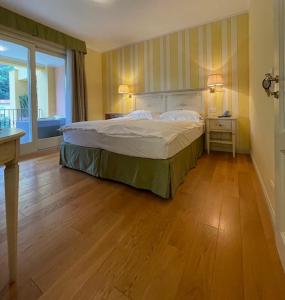 坎诺比奥Villa Palmira Kinderfreies Hotel的一间卧室设有一张大床,铺有木地板