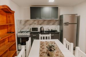 皮科将军镇Boulevard Duplex的厨房配有桌子、炉灶和冰箱。