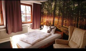 翁德洛Hotel am Naturschutzpark的卧室配有一张床和一把椅子,靠窗