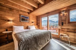 蒙特里永Chalet Heavenly Morzine - by EMERALD STAY的一间卧室设有一张床和一个大窗户