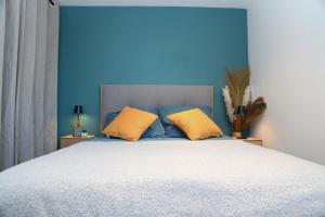 贝桑松*Hypercentre*Spacieux*Calme - Le Vauban - Cocoonhome的蓝色卧室,配有带两个黄色枕头的床