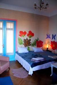 NatakhtariNapoli Nataxtari Guest house,Hostel,pool, kemping的卧室配有一张墙上鲜花的床