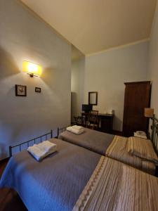 阿雷佐沃尔皮餐厅酒店的一间卧室配有两张床和一张桌子及椅子