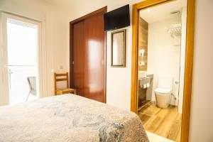 波多诺伏卡萨阿尔瓦利多旅馆的一间卧室配有一张床,浴室设有卫生间